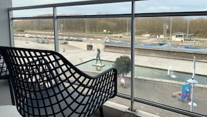 Ein Balkon mit Blick auf einen Parkplatz und eine Statue.