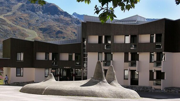 A modern building with a unique architectural design featuring a central rock-like structure.