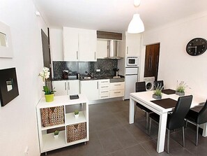 Een koelkast, een microgolfoven, kookgerei, borden en bestek