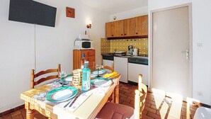 Una cocina pequeña con armarios de madera, un microondas y un rebozado de azulejos.