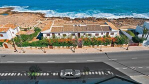 A coastal building with a tiled roof, surrounded by greenery and a view of the ocean. - Golden Life by Interhome (Jávea)