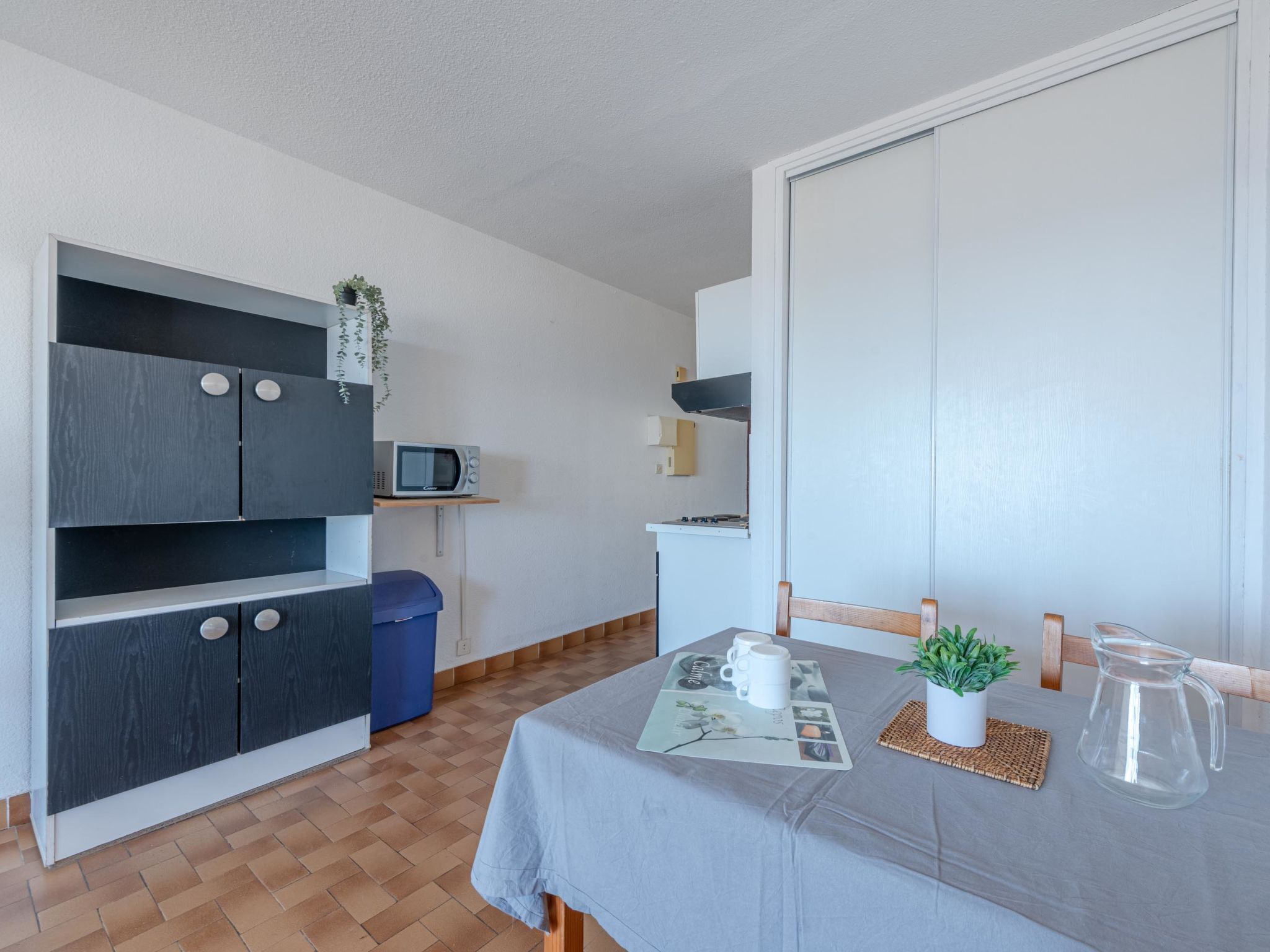 A compact kitchen with a microwave, stove, and cabinets.