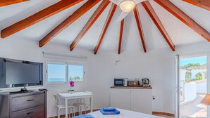 A bedroom with a bed, a desk, a TV, and a kitchenette. - Vacation home Luisa by Interhome (Calpe/Calp)