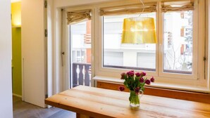 A room with a wooden bench, a vase with flowers, and a window with a curtain. - Chesa La Soliva by Interhome (St. Moritz)