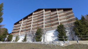 A multi-story building with a modern architectural design, featuring balconies on each floor.