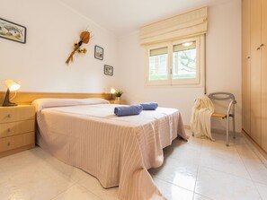 2 dormitorios y tabla de planchar con plancha