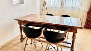 A dining area with a wooden table and two upholstered chairs. - Apartment Diana by Interhome (Münster)