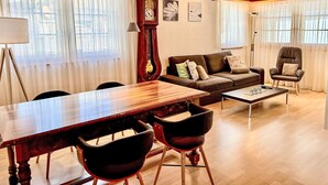 A cozy living room with a wooden dining table, two sofas, and a coffee table. - Apartment Diana by Interhome (Münster)
