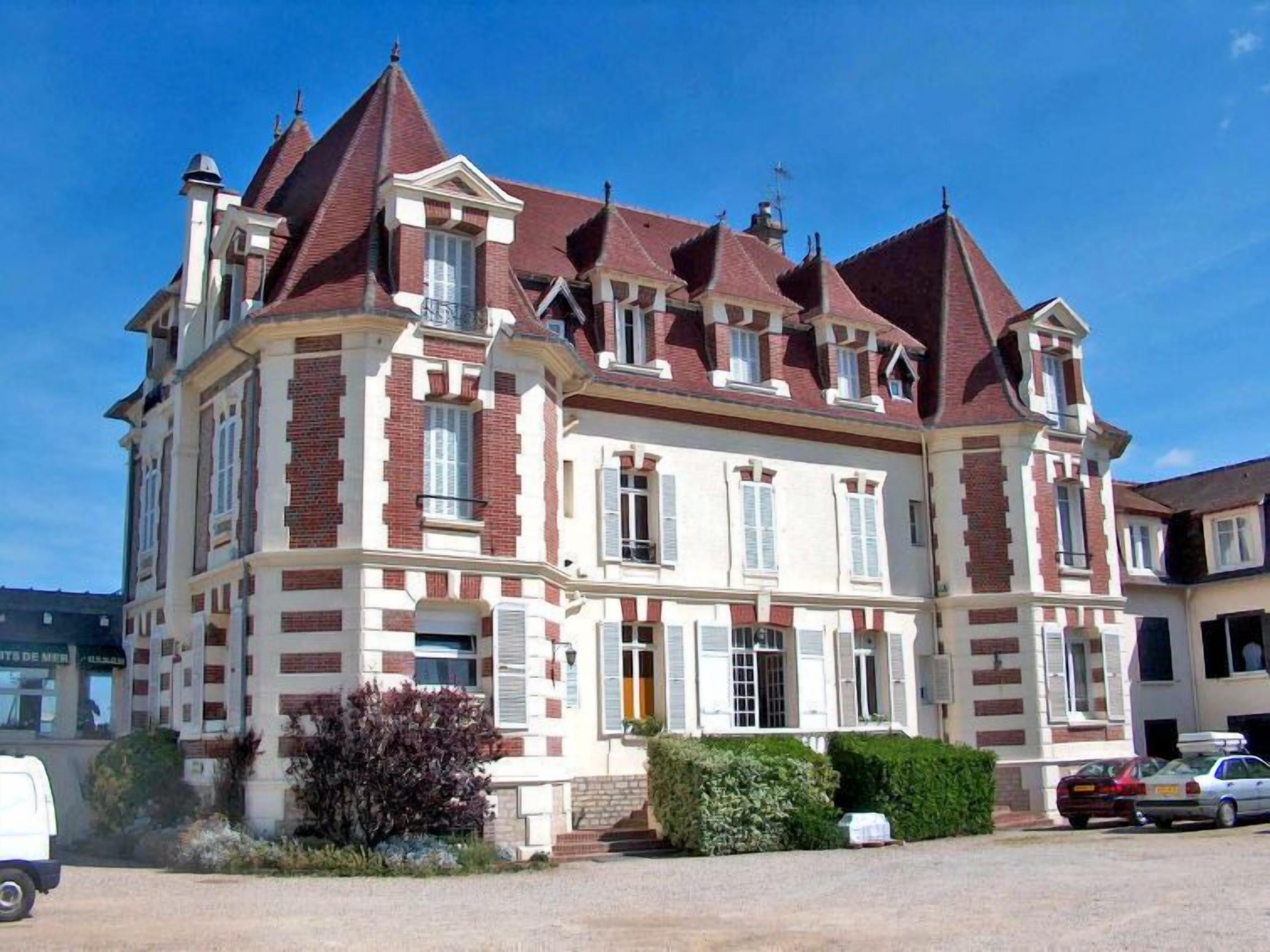 Ein großes, historisches Gebäude mit zahlreichen Schornsteinen und einer symmetrischen Fassade.