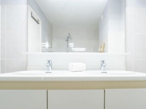 A modern bathroom with a double sink, a glass shower enclosure, and a mirror above the sink. - Zandloper II with balcony by Interhome (Bredene)