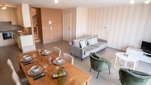 A modern living space with a dining area, a sofa, and a TV. - Zandloper II with balcony by Interhome (Bredene)