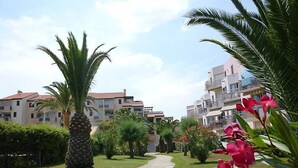 A pathway leading to a residential area with modern buildings, palm trees, and well-maintained greenery. - Les Capitelles by Interhome (Saint Cyprien)