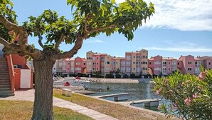 Une cour avec une piscine, des bateaux et un arbre.