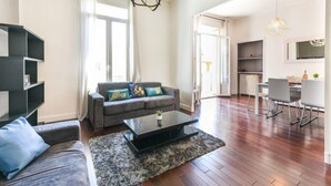 Ein modernes Wohnzimmer mit einer Couch, einem Couchtisch und einem Essbereich mit Stühlen und einem Tisch.