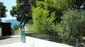 A coastal residential area with a view of the sea, a metal fence, and a bicycle parked near a building. - Apartment Ante by Interhome (Brodarica)