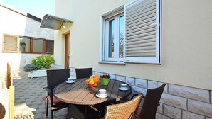 A patio with a round table, four chairs, and a potted plant. - Apartment Ante by Interhome (Brodarica)