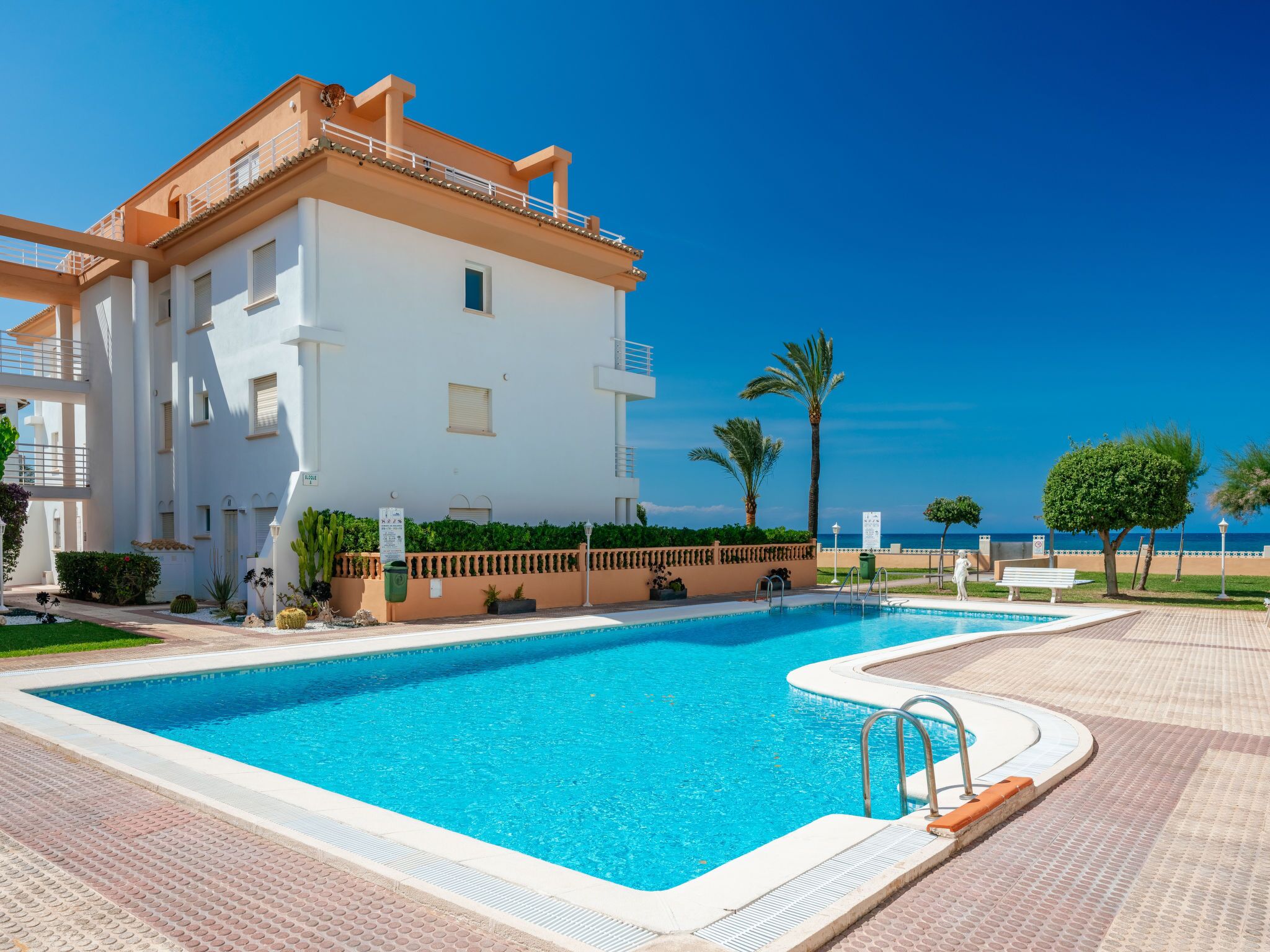 Une piscine avec un bâtiment blanc en arrière-plan.