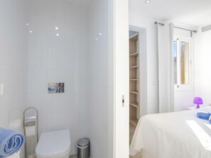 Een badkamer met toilet, douche en een handdoekhouder.