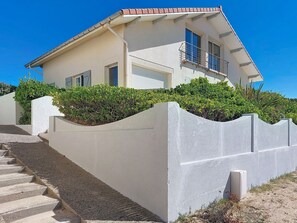 A two-story house with a sloped roof, a balcony, and a staircase leading to the entrance. - Apartment Capama by Interhome (Mimizan)