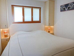 Relax in a serene space with a single bed, bedside tables, and a decorative wall piece.