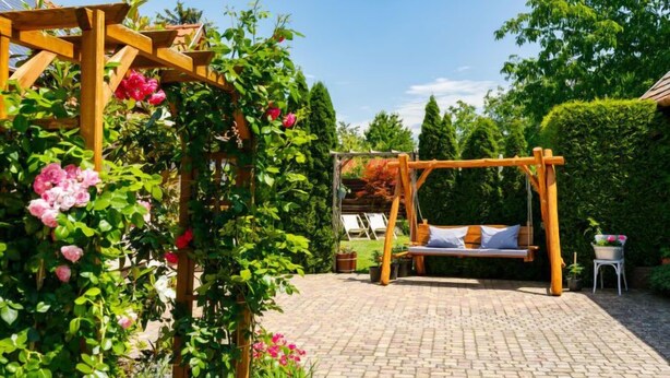 Un jardín con un porche de madera y una hamaca.