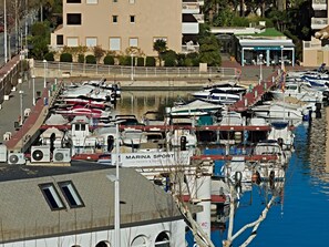 Ein Yachthafen mit angestaubten Booten, ein Gebäude mit der Aufschrift "MARINA SPORT" und ein Schild für "AMARRIS 152".