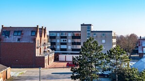 A multi-story residential building with a parking area in front. - Deichblick by Interhome (Norddeich)
