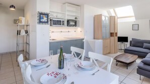 Eine moderne Wohnung mit Essbereich, Küche und Wohnbereich.