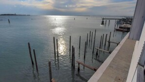 A waterfront view with a dock extending into calm water, a distant shoreline, and a clear sky. - Apartment Iris by Interhome (Venezia Giudecca)