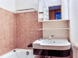 Ein Badezimmer mit Badewanne, Waschbecken und Spiegel.