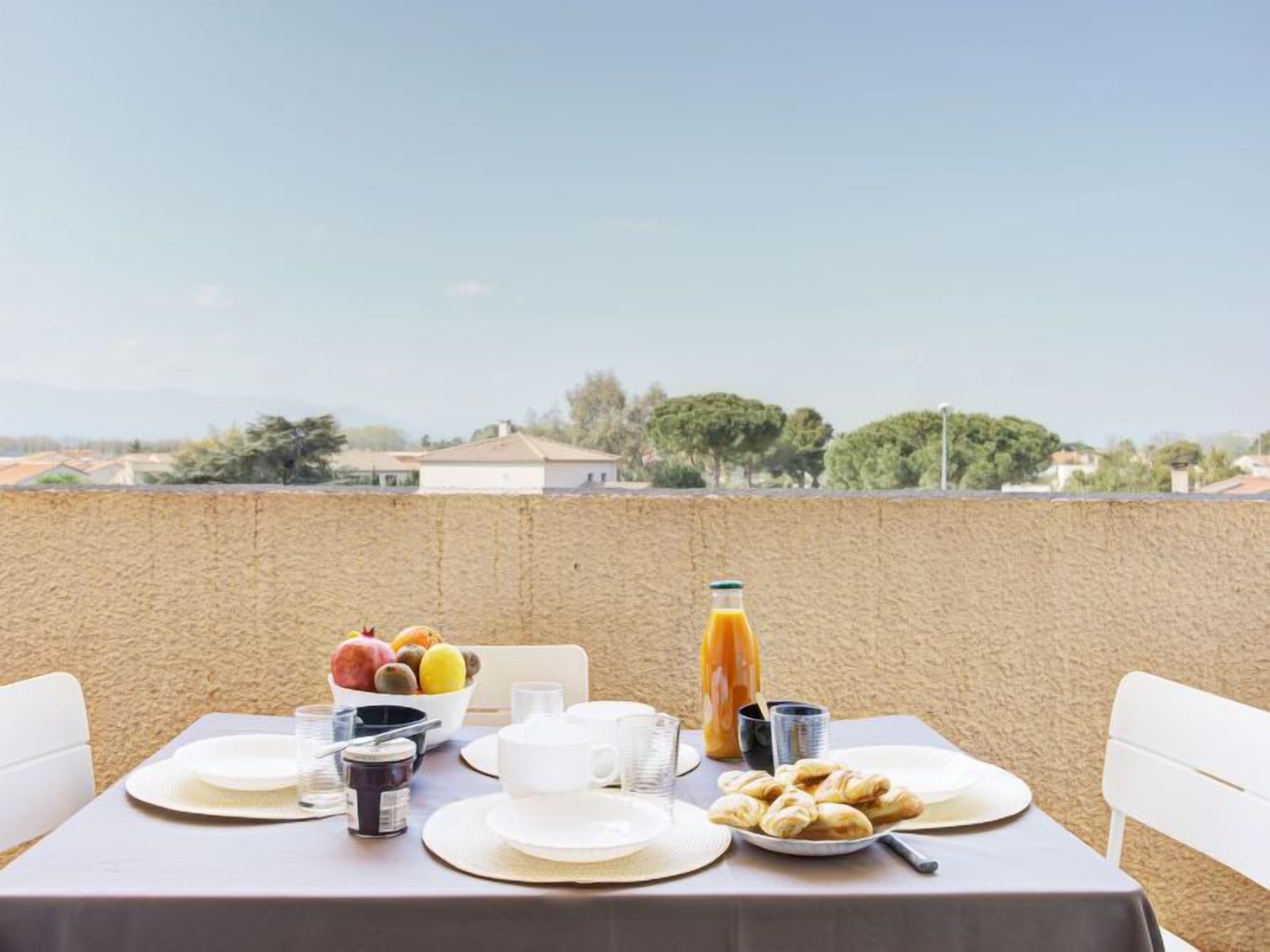 A table set for breakfast with a view of a rural landscape.