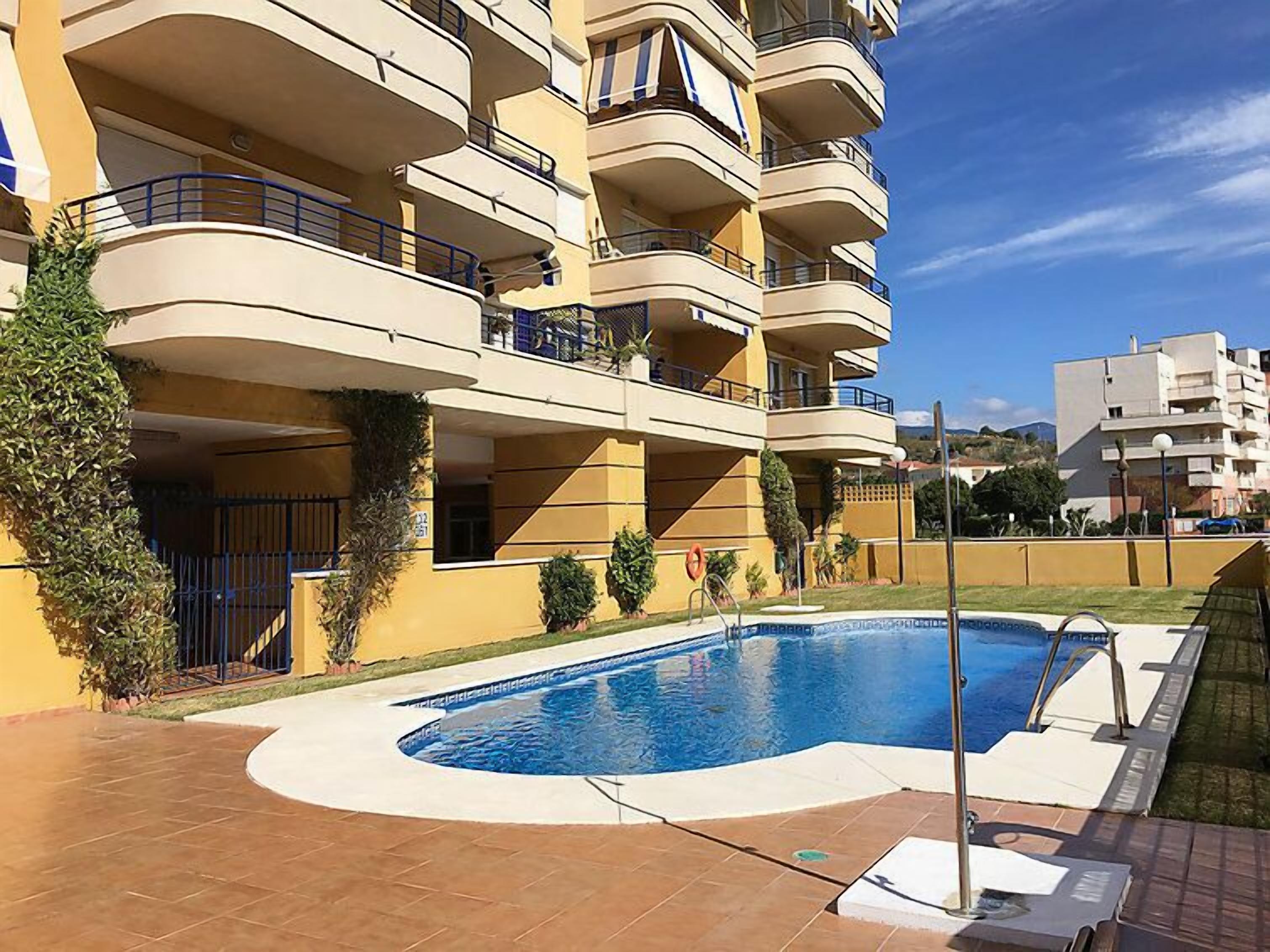 A multi-story residential building with a swimming pool.