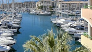 A marina with numerous boats docked, surrounded by buildings with balconies. - Bleu Marine by Interhome (Fréjus)