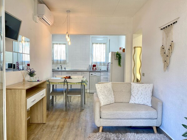 A compact living space with a kitchenette, a dining area, and a seating area. - Aquarius by Interhome (Tossa de Mar)
