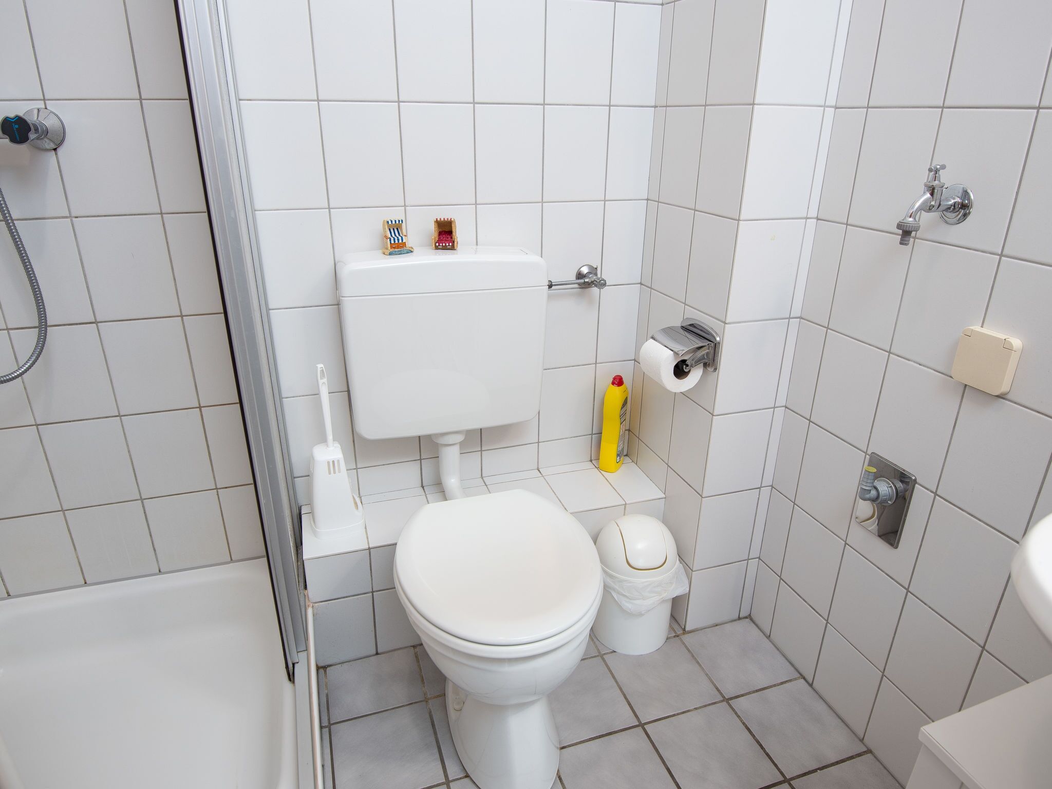 A small, clean bathroom with a toilet, bidet, and shower.