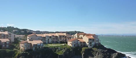 Un quartier résidentiel situé sur la côte, avec plusieurs immeubles construits sur une falaise surplombant la mer.