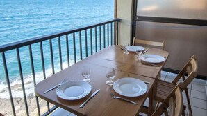 A dining table set with plates, cutlery, and glasses on a balcony overlooking the sea. - Les Roches Bleues by Interhome (Collioure)