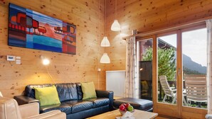 A cozy room with a leather sofa, a wooden coffee table, and a painting on the wall. - Rietsli by Interhome (Grächen)