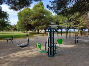Un parc équipé d’appareils de musculation, de bancs et d’arbres.