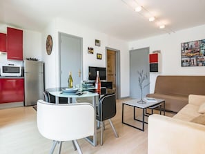 A modern apartment with a dining area, kitchen, and living room.