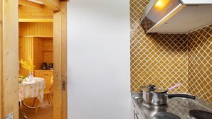 A kitchen with a stainless steel stove, a white wall, and a patterned backsplash. - Eldorado 321 by Interhome (Verbier)