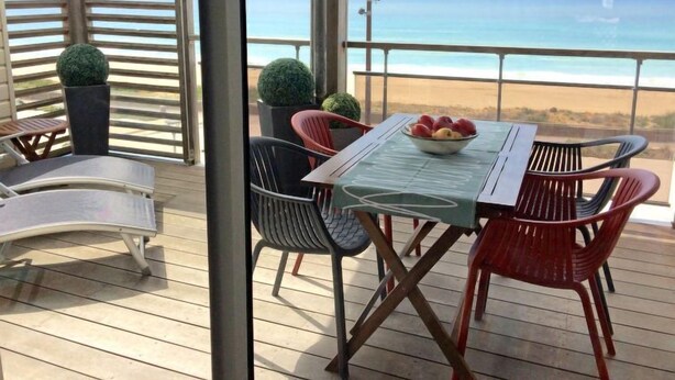 A deck with a table and chairs, overlooking a beach. - Horizon by Interhome (Mimizan)
