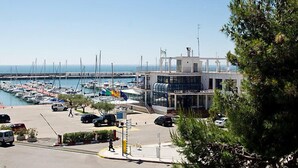 A marina with boats docked, a building labeled "Club de la Marina," and a clear view of the sea. - Edificio Nautic by Interhome (L'Ampolla)