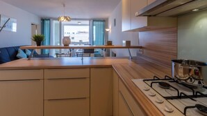 Une cuisine moderne dotée d’un îlot central, de meubles encastrés et d’une cuisinière à gaz.