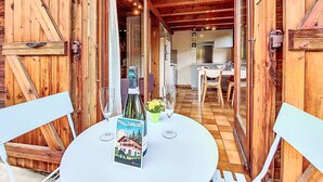 A wooden exterior with a glass door leading to a kitchen and dining area.