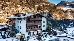 A multi-story hotel with a modern design, located in a mountainous area with snow-covered surroundings. - Bichleregg by Interhome (Ötz)