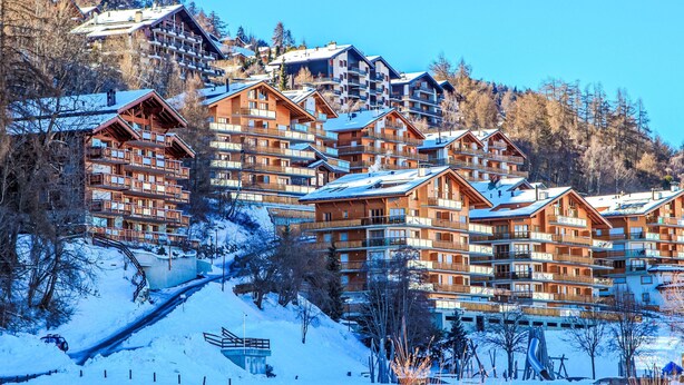 A snow-covered mountain resort with multiple wooden buildings, including a ski lift and a chairlift. - Grand Panorama A11 by Interhome (Nendaz)