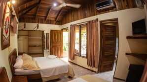 Una stanza con due letti, soffitto in legno e ventilatore a soffitto.