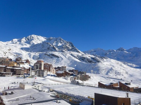 A snow-covered mountain town with buildings and a ski slope.