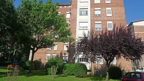 Un immeuble à plusieurs étages, doté d’une façade en briques et de cadres de fenêtres blancs.